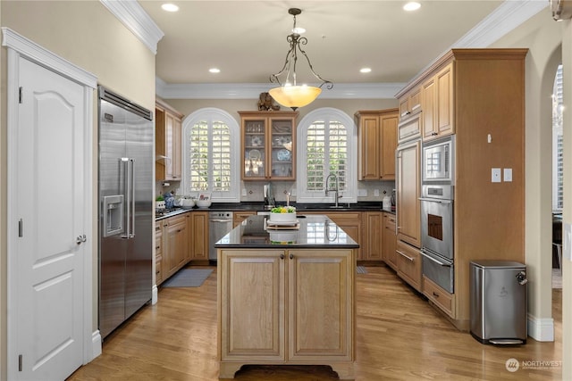 kitchen featuring built in appliances, decorative light fixtures, a center island, light hardwood / wood-style floors, and decorative backsplash