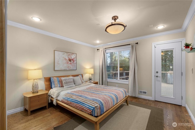 bedroom with wood-type flooring, ornamental molding, and access to exterior