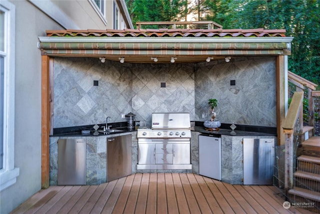 wooden deck with an outdoor kitchen, grilling area, and sink