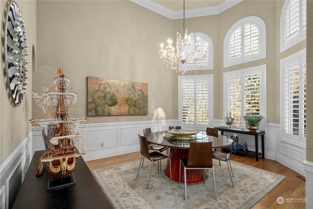 dining room with a chandelier, hardwood / wood-style floors, and crown molding