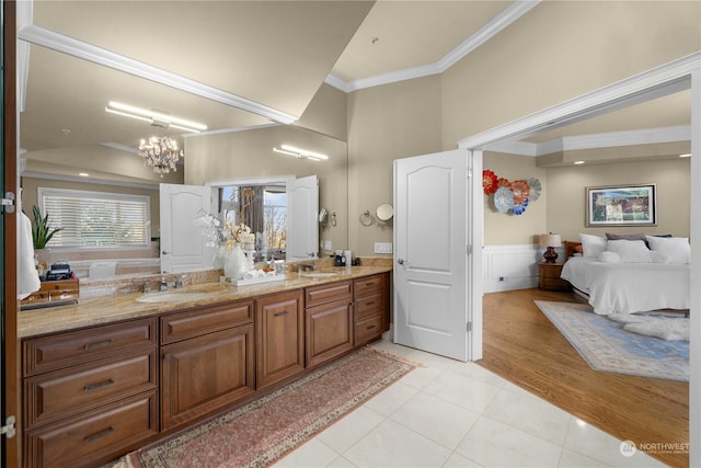 bathroom with ornamental molding, tile patterned flooring, a notable chandelier, and vanity