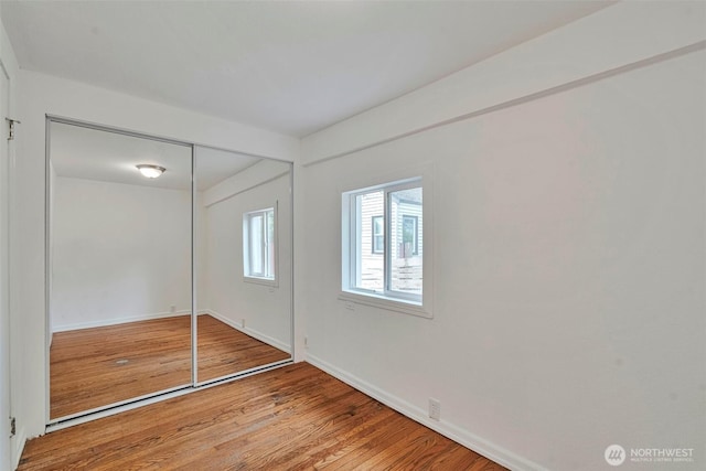 11427 Military Rd, Seattle, WA 98168 - unfurnished bedroom with wood finished floors, baseboards, and a closet