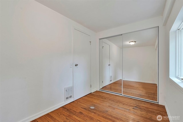 11427 Military Rd, Seattle, WA 98168 - unfurnished bedroom with wood finished floors, baseboards, and a closet