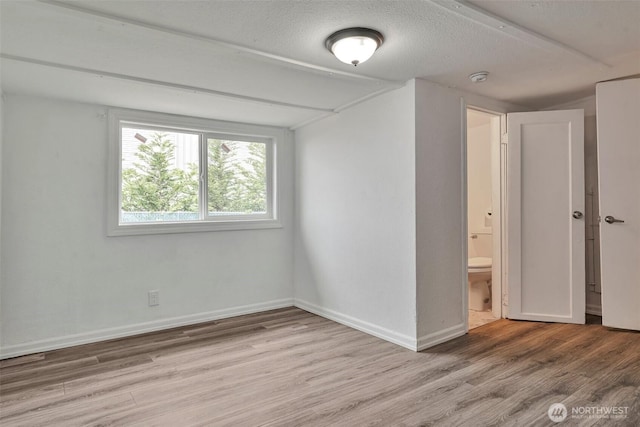 11427 Military Rd, Seattle, WA 98168 - empty room featuring wood finished floors, baseboards, a textured ceiling, and a smoke detector