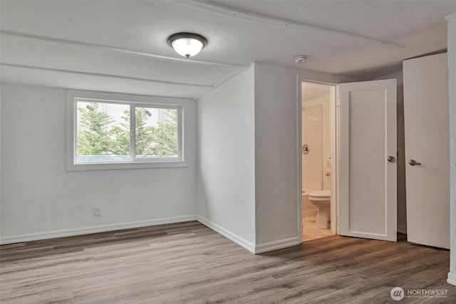 11427 Military Rd, Seattle, WA 98168 - unfurnished bedroom featuring wood finished floors, baseboards, and ensuite bathroom
