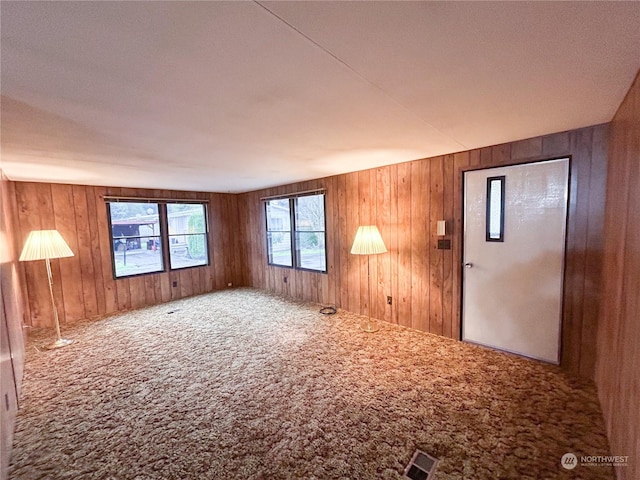 interior space featuring carpet flooring and wooden walls