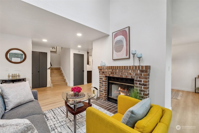 living room featuring light wood-type flooring and a brick fireplace