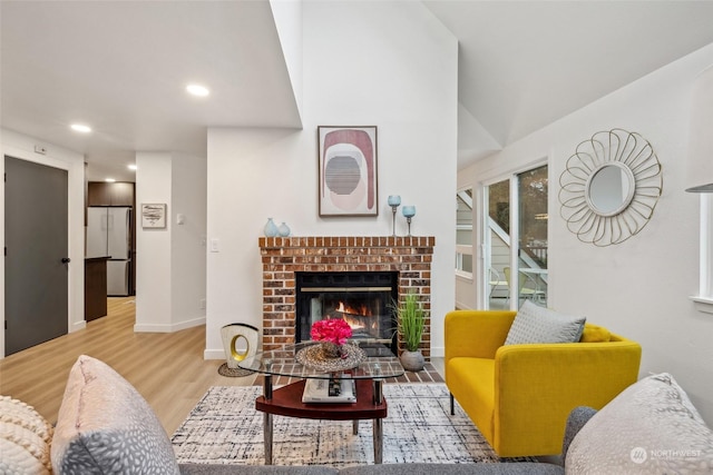 living room featuring hardwood / wood-style floors and a brick fireplace