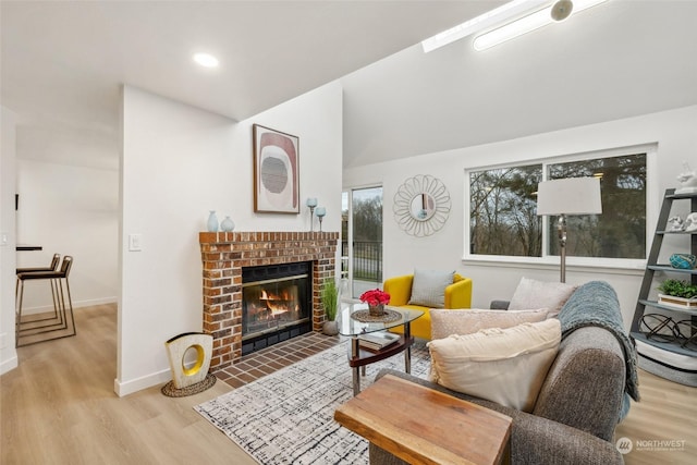 living room with a brick fireplace and light wood-type flooring