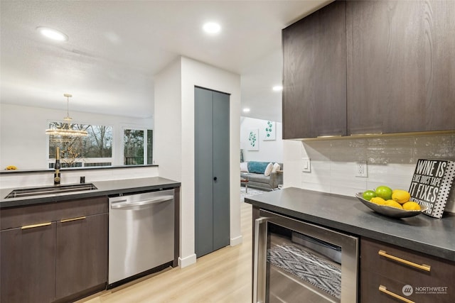 kitchen with sink, wine cooler, stainless steel dishwasher, light wood-type flooring, and dark brown cabinetry