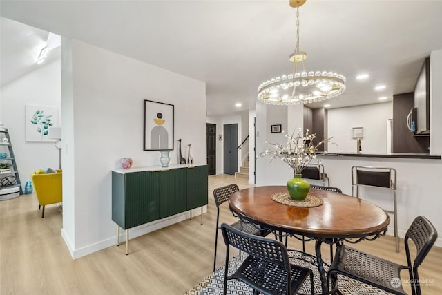 dining area with a chandelier and light hardwood / wood-style floors