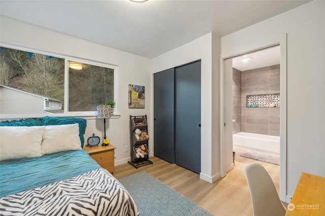 bedroom featuring light wood-type flooring, a closet, and connected bathroom