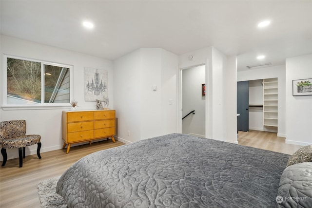 bedroom featuring a spacious closet, a closet, and wood-type flooring