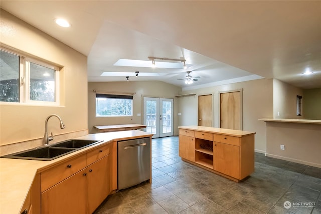 kitchen with lofted ceiling with skylight, light countertops, dishwasher, and a sink