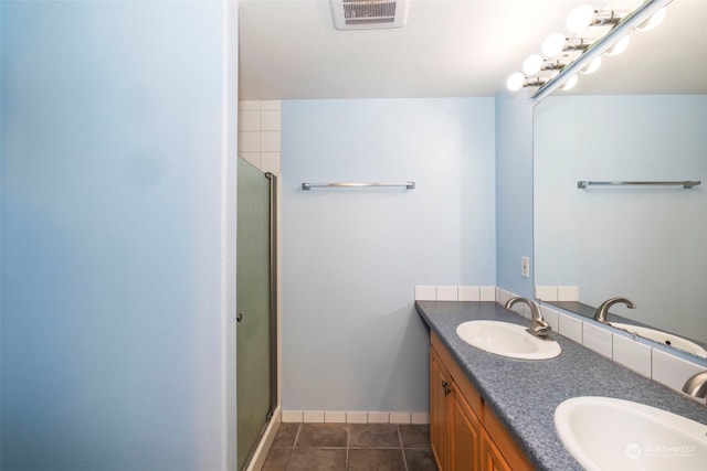 bathroom featuring double vanity, visible vents, a sink, and tile patterned floors