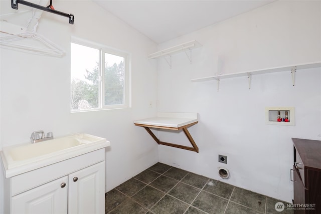 clothes washing area featuring dark tile patterned flooring, washer hookup, a sink, and electric dryer hookup