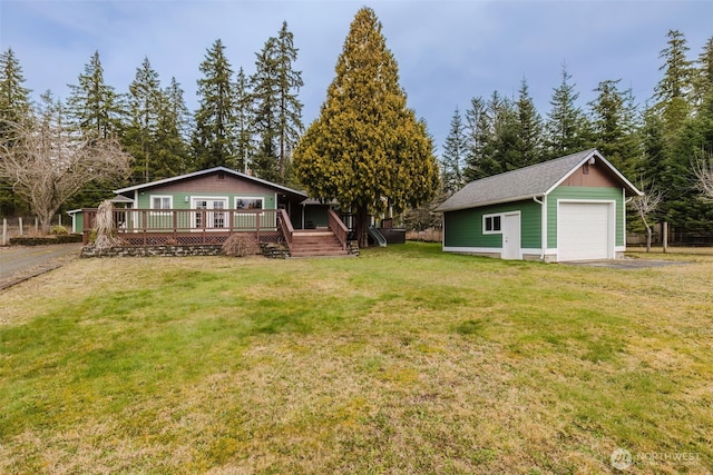 view of yard featuring a garage, an outdoor structure, a wooden deck, and aphalt driveway