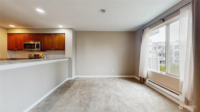 kitchen with plenty of natural light, decorative backsplash, stainless steel appliances, and a baseboard radiator