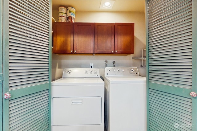 laundry room with washer and dryer and cabinets