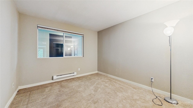 carpeted spare room with a baseboard heating unit