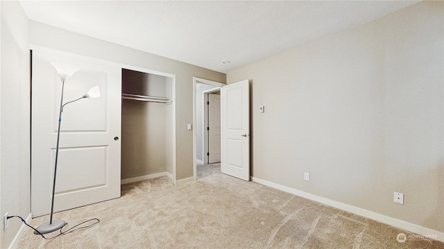 unfurnished bedroom with light colored carpet and a closet