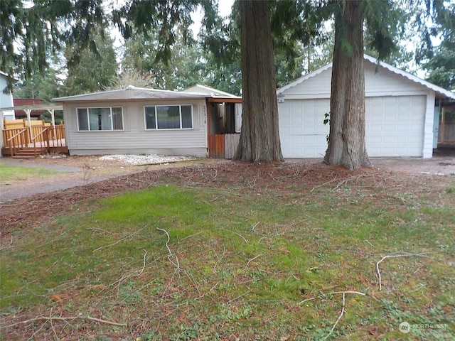 single story home with an outdoor structure, a garage, and a wooden deck