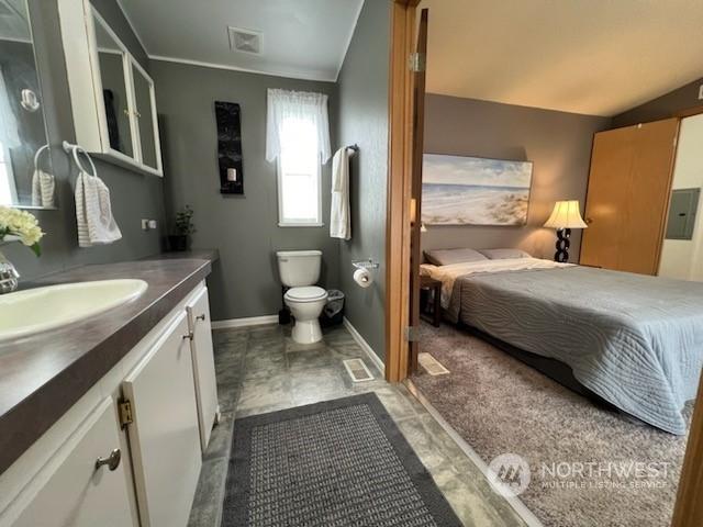 bathroom featuring vanity, electric panel, tile patterned floors, vaulted ceiling, and toilet