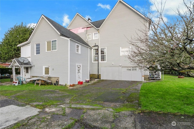 view of side of property featuring a yard and a garage