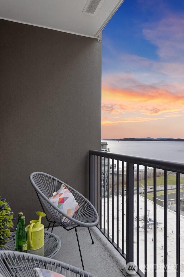 balcony with a water view and visible vents