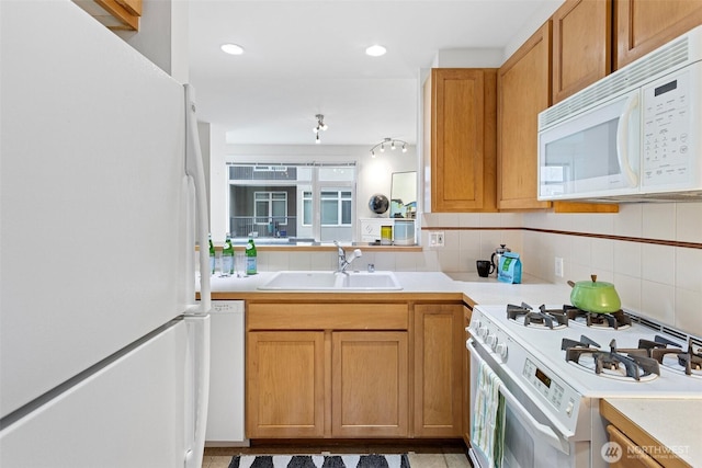 kitchen featuring recessed lighting, white appliances, a sink, light countertops, and decorative backsplash