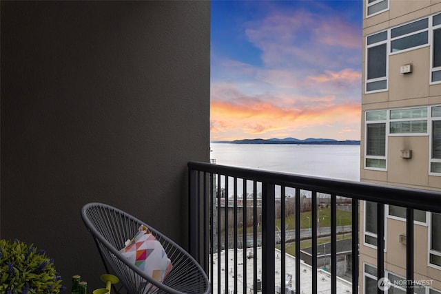 balcony at dusk with a water and mountain view