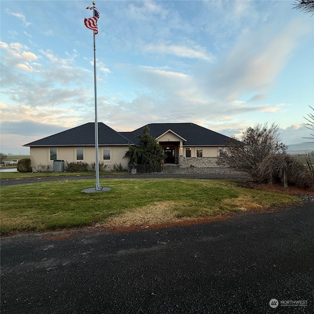 view of front of home with cooling unit and a front yard