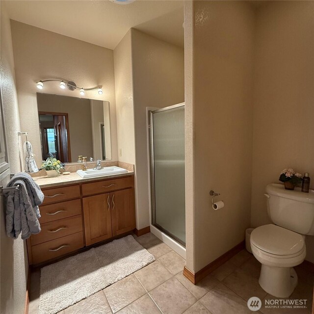 1078 Gardena Creek Rd, Touchet, WA 99360 - bathroom featuring vanity, tile patterned flooring, a stall shower, toilet, and baseboards