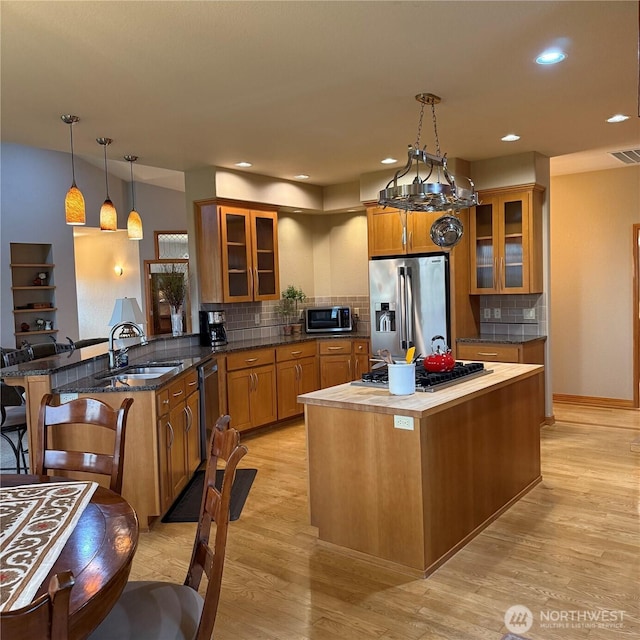 1078 Gardena Creek Rd, Touchet, WA 99360 - kitchen featuring stainless steel appliances, a sink, brown cabinets, a breakfast bar, and recessed lighting