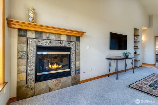 1078 Gardena Creek Rd, Touchet, WA 99360 - carpeted living room featuring a tile fireplace, baseboards, a towering ceiling, and built in features