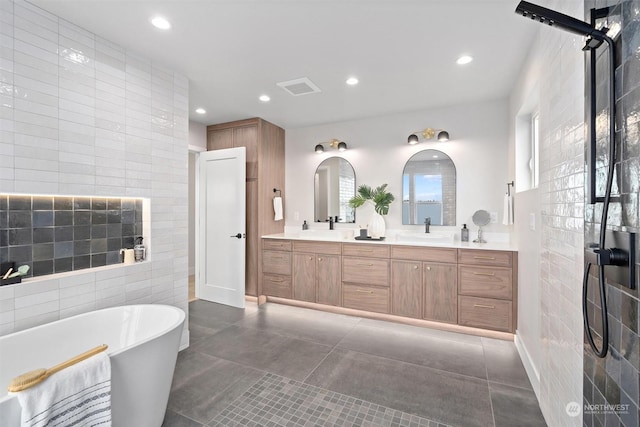 bathroom with tile walls, a bathtub, concrete floors, and vanity