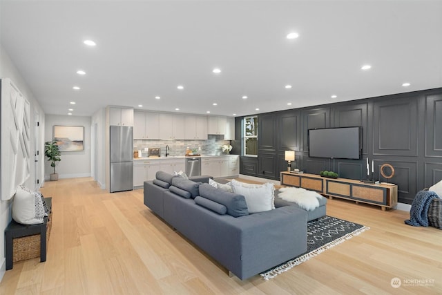 living room with sink and light hardwood / wood-style floors