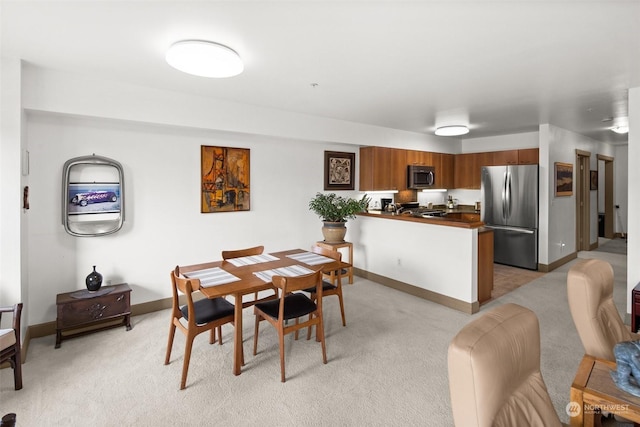 dining space featuring light carpet