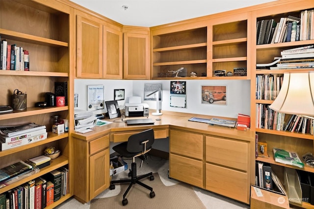 home office featuring light carpet and built in desk