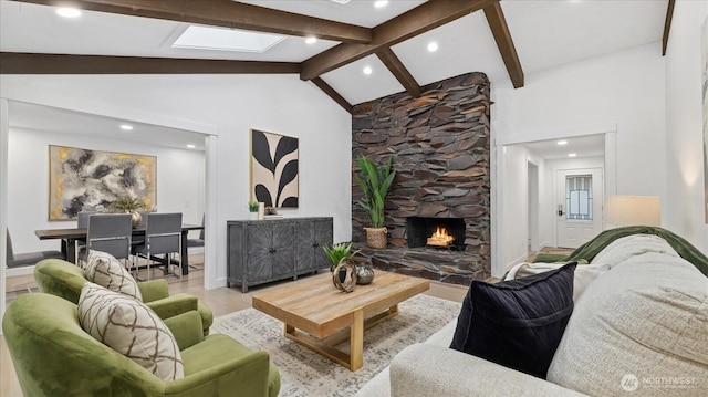 living area featuring a stone fireplace, a skylight, wood finished floors, and beam ceiling