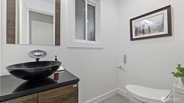 bathroom with vanity, toilet, and baseboards