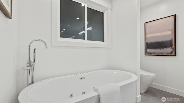 full bathroom featuring toilet, a soaking tub, and baseboards