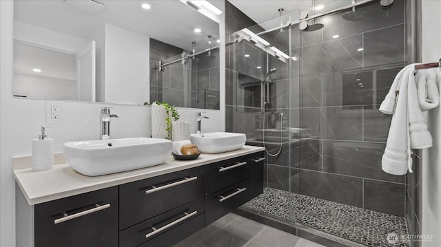 bathroom with double vanity, a sink, and a shower stall