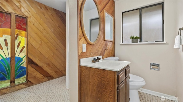 half bath featuring wooden walls, toilet, and vanity