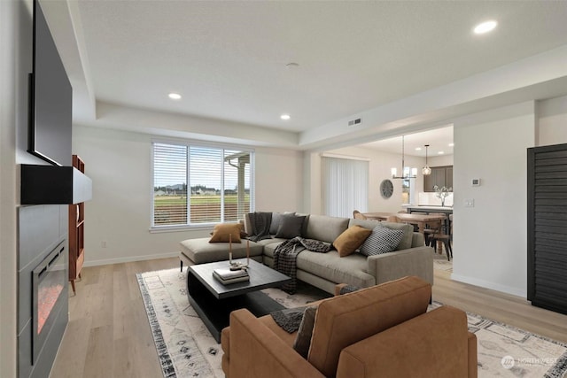 living room featuring light hardwood / wood-style flooring and a notable chandelier