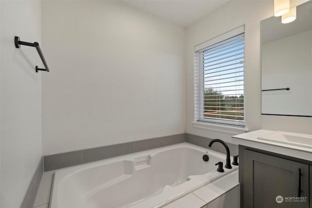 bathroom featuring vanity and tiled tub