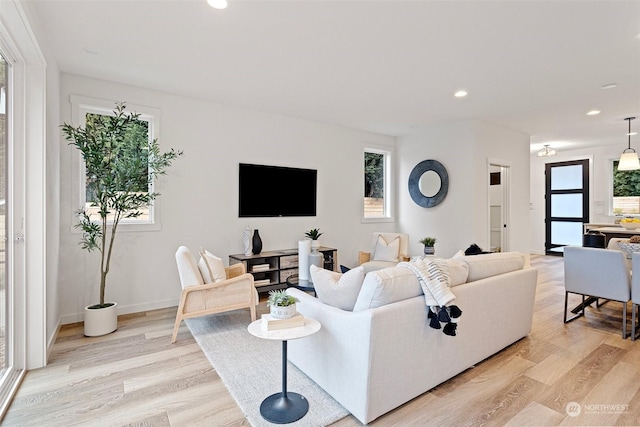 living room with recessed lighting, light wood-style floors, and baseboards