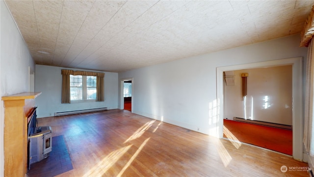 unfurnished living room featuring wood-type flooring and a baseboard radiator