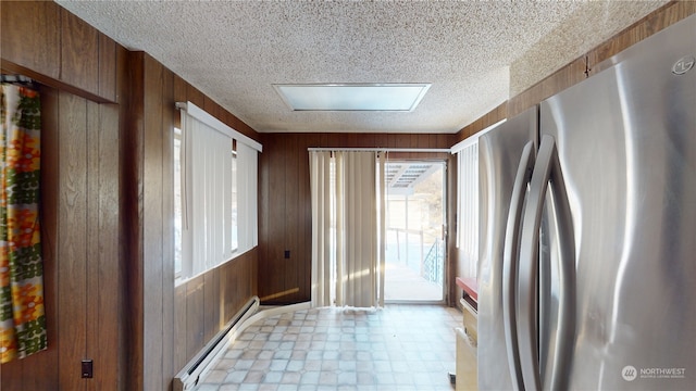 doorway featuring a skylight, wooden walls, and a baseboard radiator