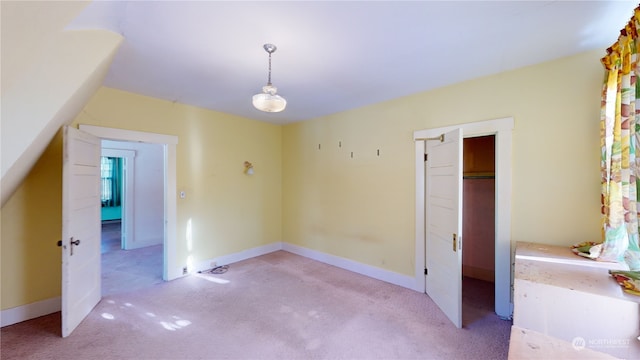 unfurnished bedroom featuring light carpet and a closet